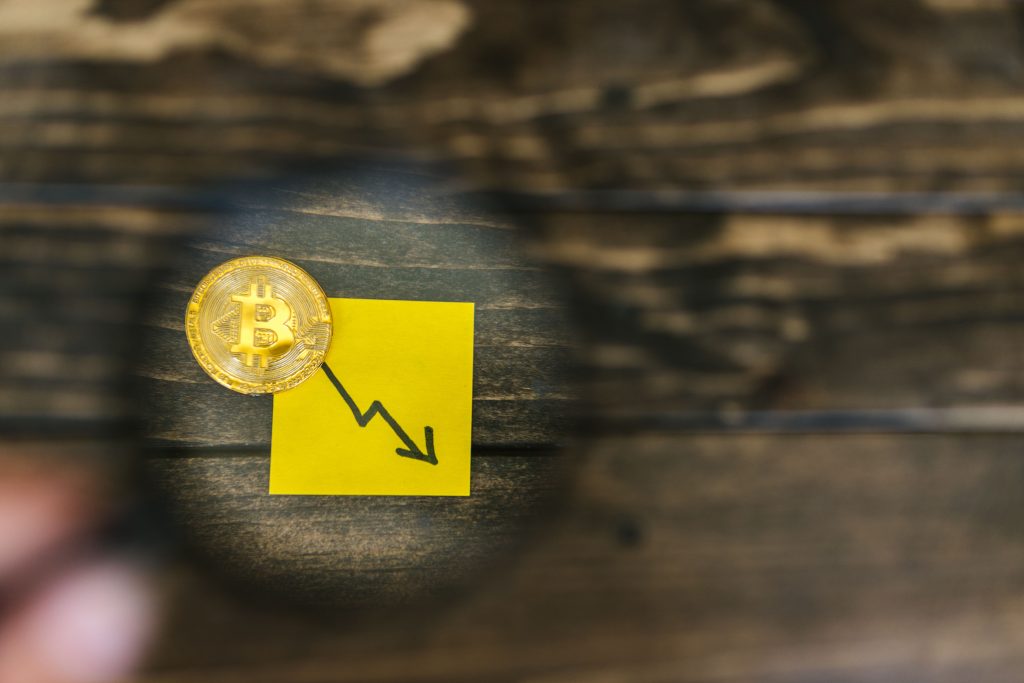 A gold Bitcoin and downward trend arrow symbolizing cryptocurrency market decline