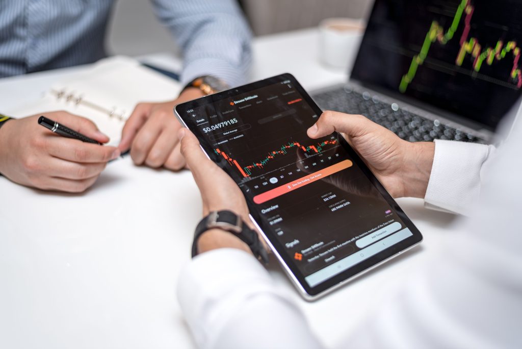Professionals analyzing cryptocurrency data on a digital tablet during a business meeting