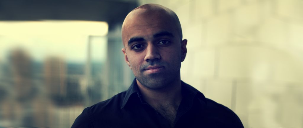 Portrait of Haseeb Qureshi in a dark shirt