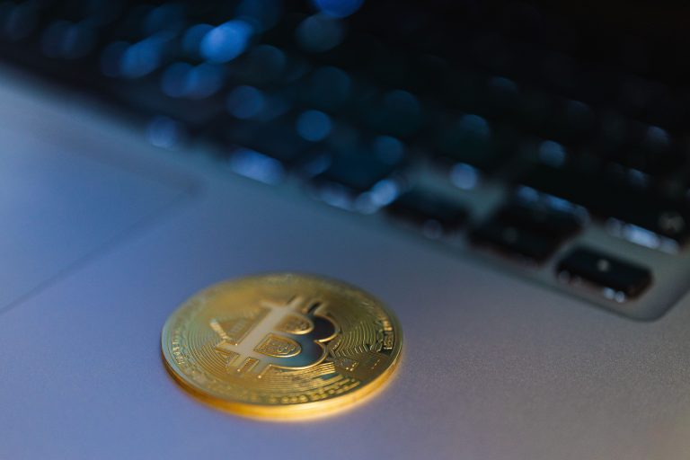 Close-up of a Bitcoin coin on a laptop, symbolizing digital currency and technology